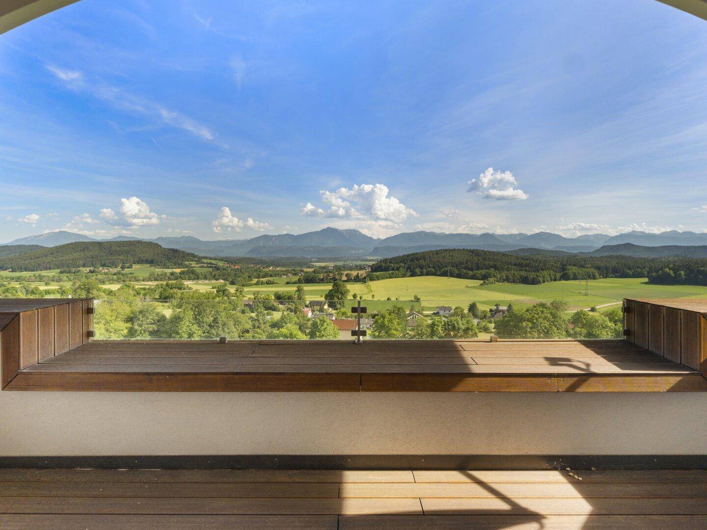 Atemberaubender Panoramablick vom Balkon über grüne Hügel und ferne Berge.