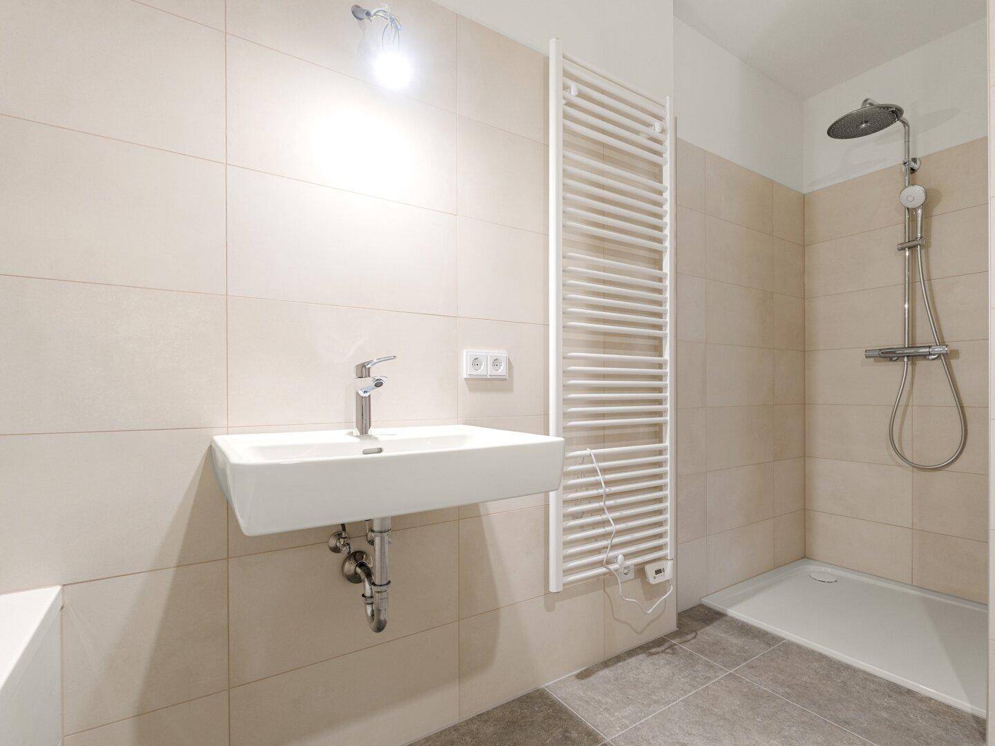Modernes Badezimmer mit beigen Fliesen, ebenerdiger Dusche, Regenbrause und Handtuchheizkörper.