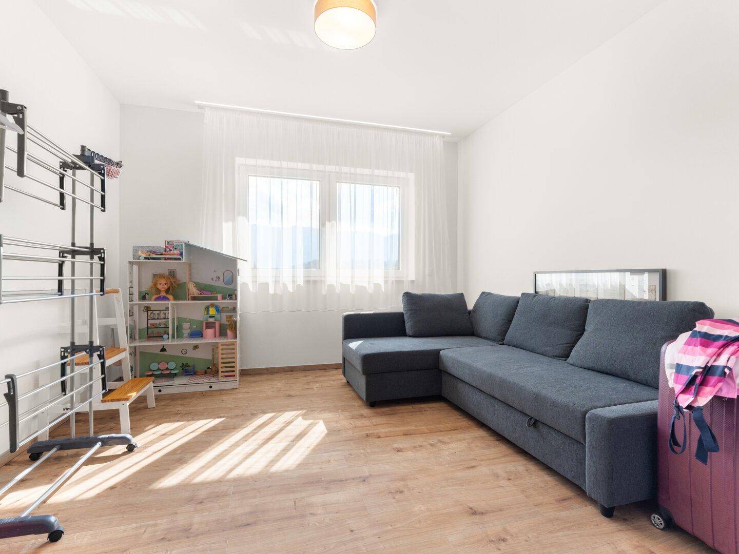 Helles Zimmer mit Schlafsofa, Holzboden und viel Tageslicht.