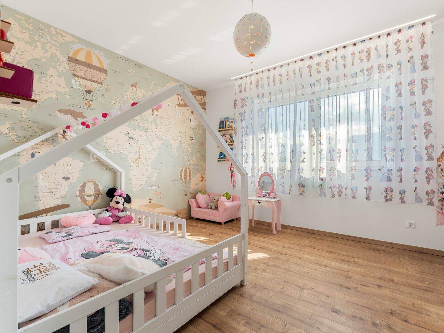 Kinderzimmer mit thematischer Tapete, Holzbett und verspielter Dekoration.