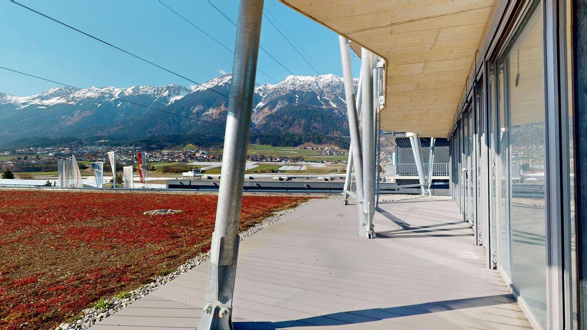 Geräumige Dachterrasse mit weitem Blick auf die umliegende Bergwelt und die grüne Landschaft.