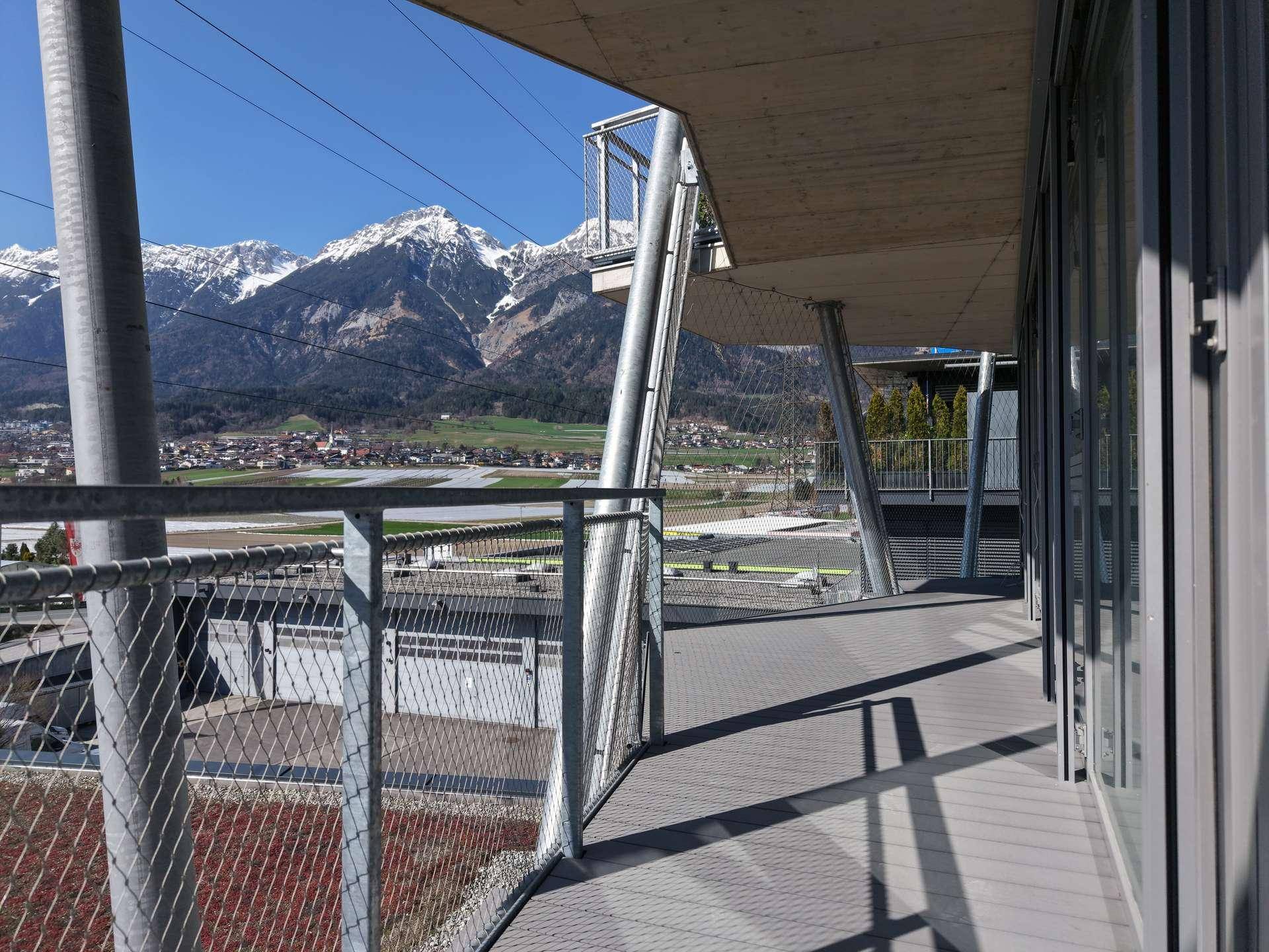 Offener Balkonbereich mit Metallgeländer und beeindruckendem Blick auf die schneebedeckten Berge.