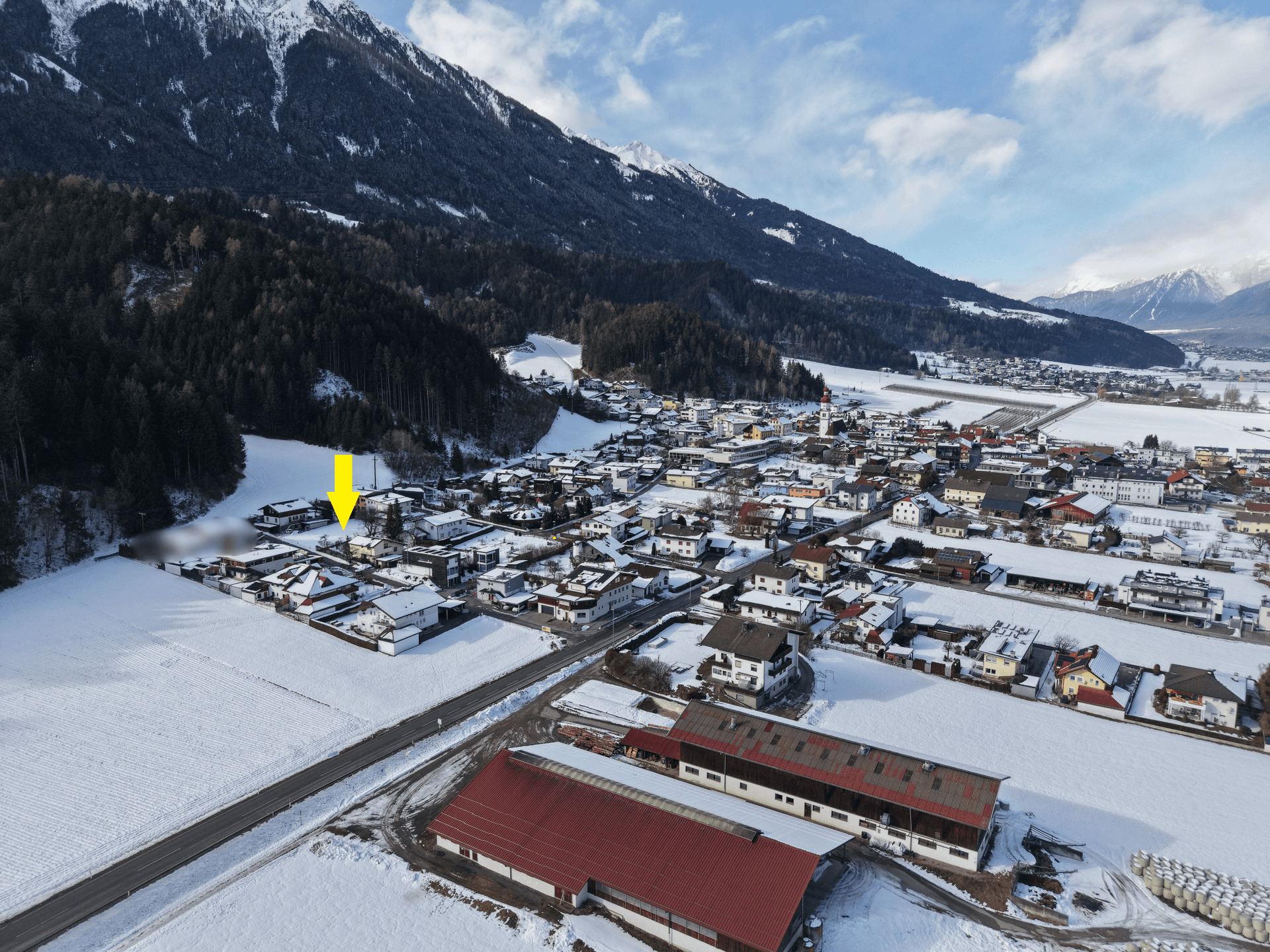 Übersicht des Standorts des Grundstücks innerhalb des schneebedeckten Dorfes, eingebettet in eine Berglandschaft.