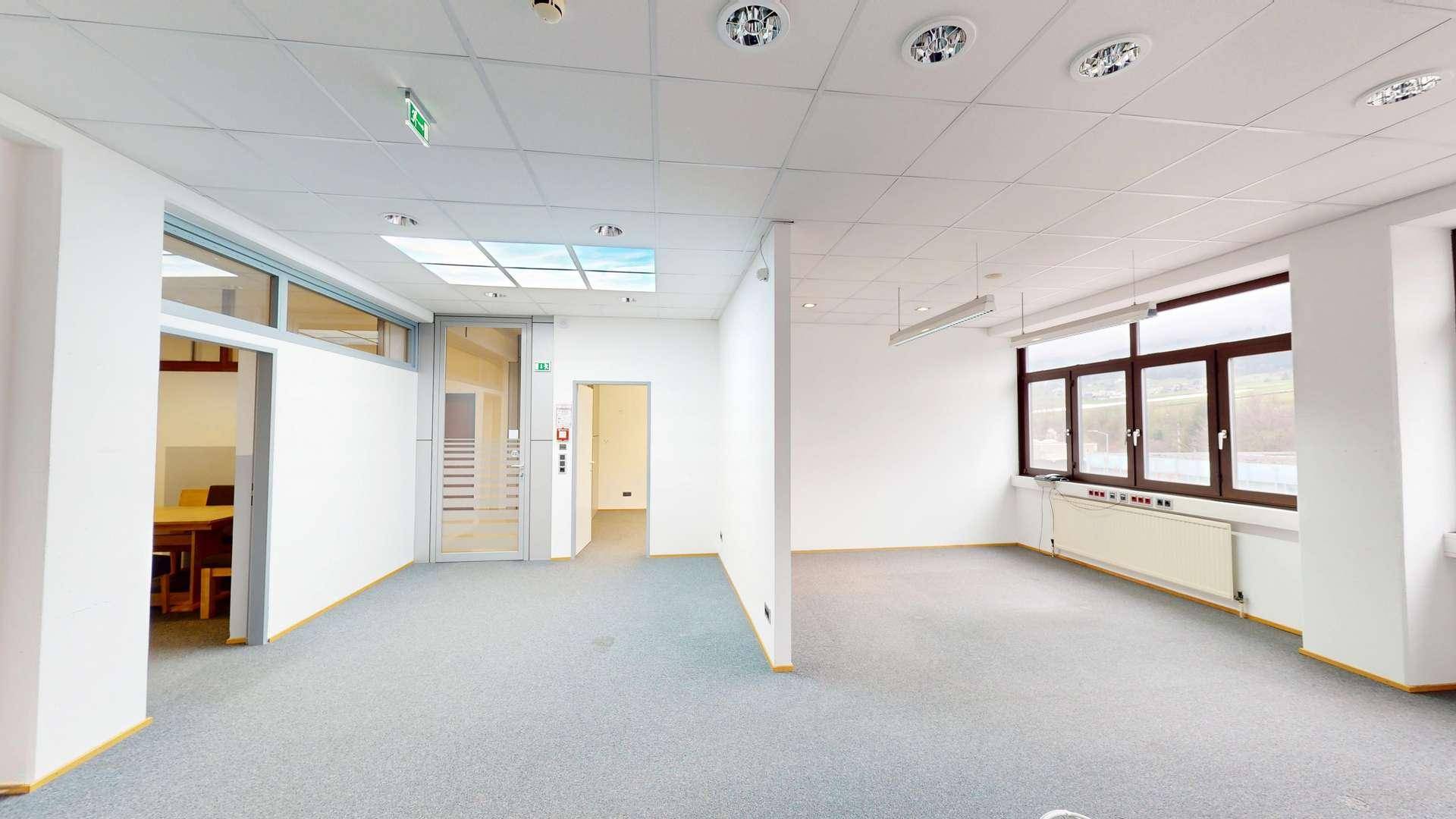 Geräumiges, leeres Büro mit großen Fenstern, ideal für flexible Arbeitsplatzgestaltung und viel Tageslicht.