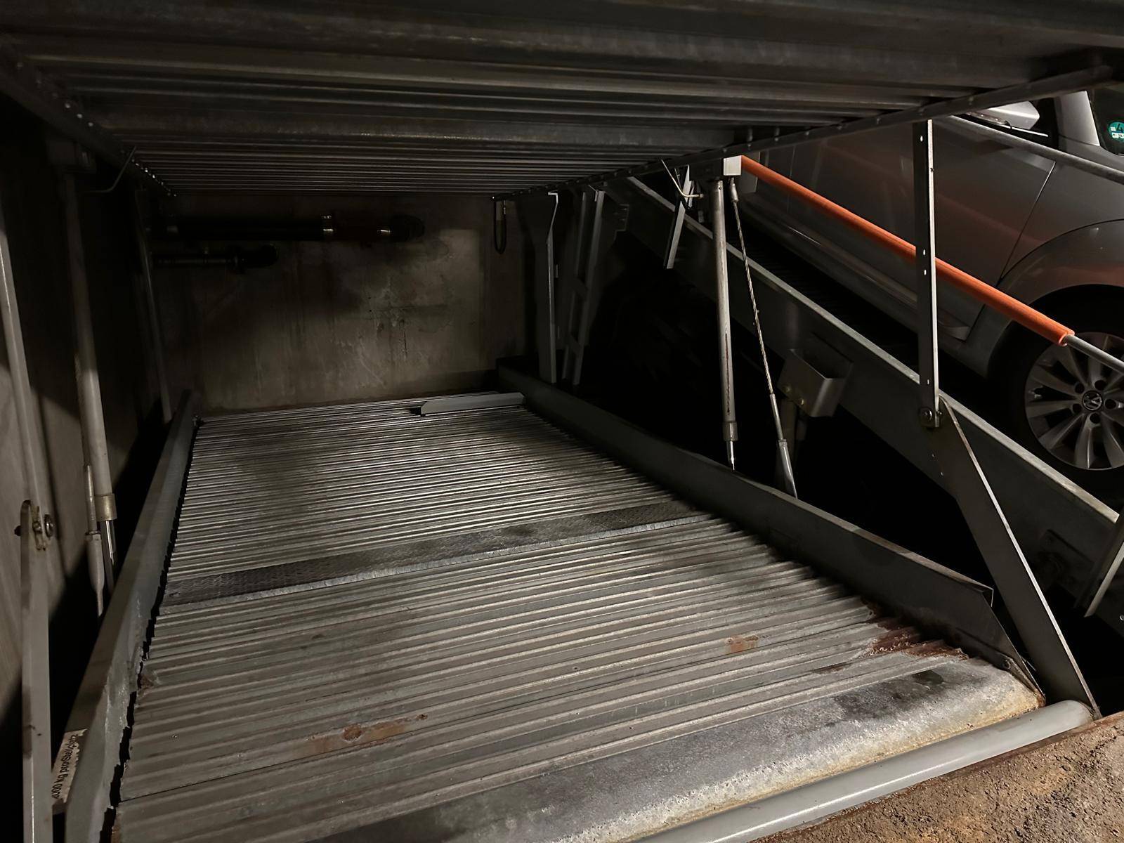 Detailansicht eines Doppelparker-Systems in einer Tiefgarage mit Metallplattform.