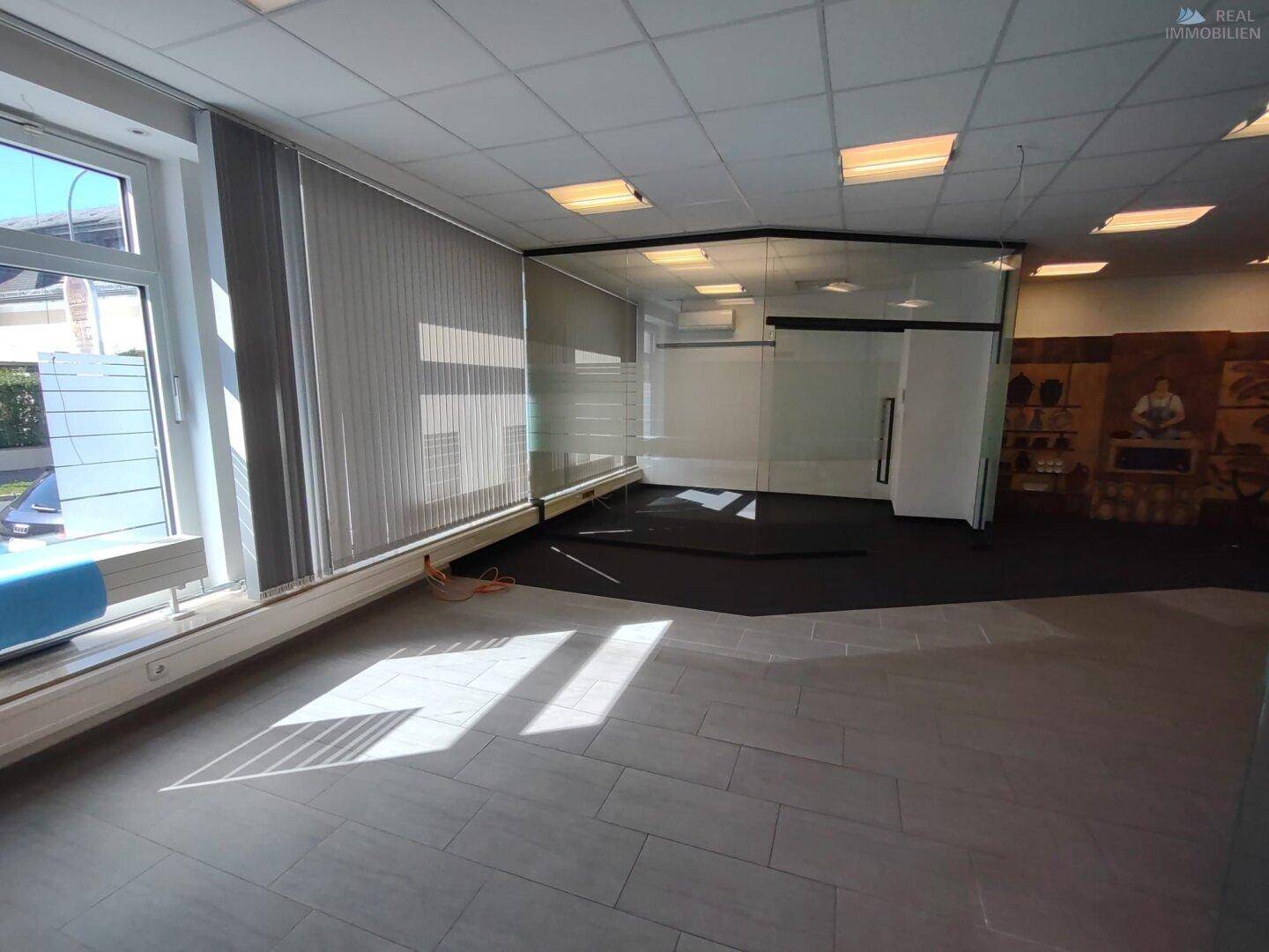 Flexibler Bürobereich mit Fliesen- und Teppichboden, großen Fenstern und viel Tageslicht.