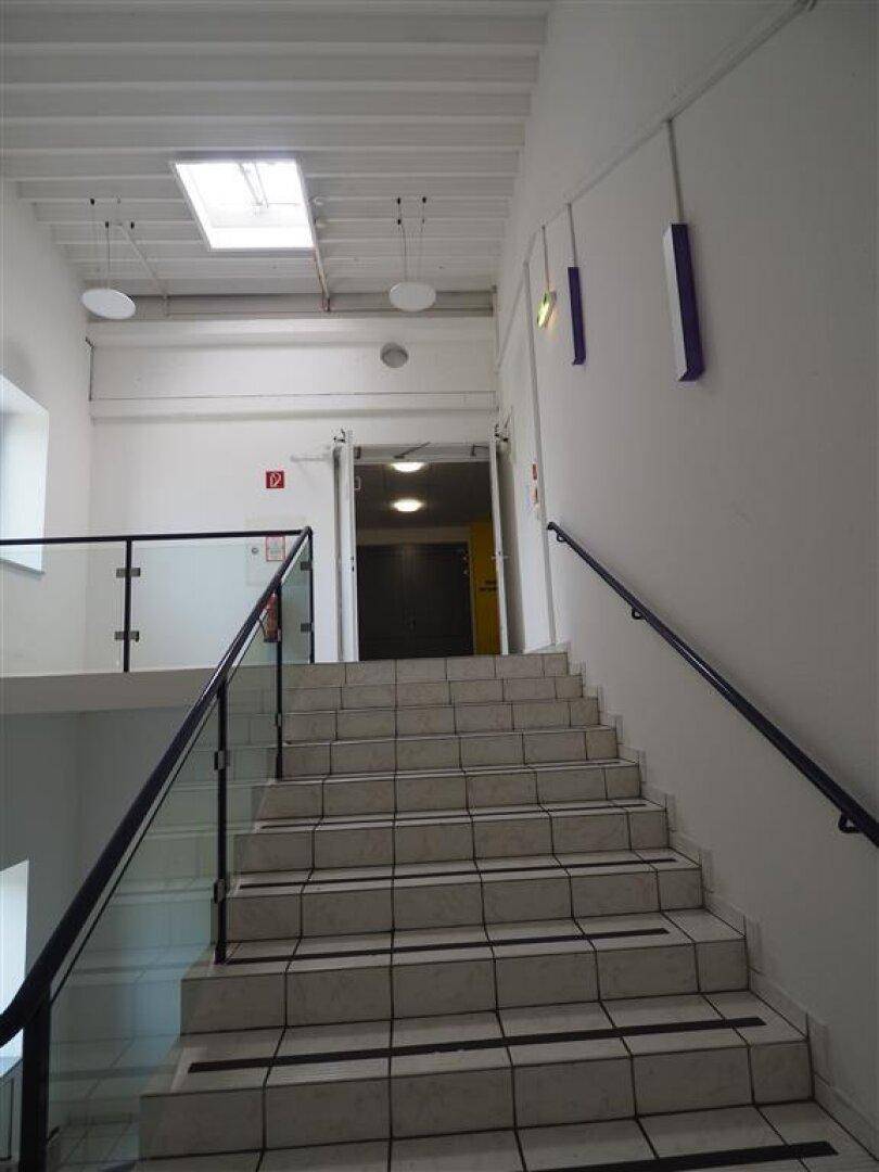 Helles Treppenhaus mit Oberlicht, das für viel natürliches Licht sorgt, und einem modernen Geländer.