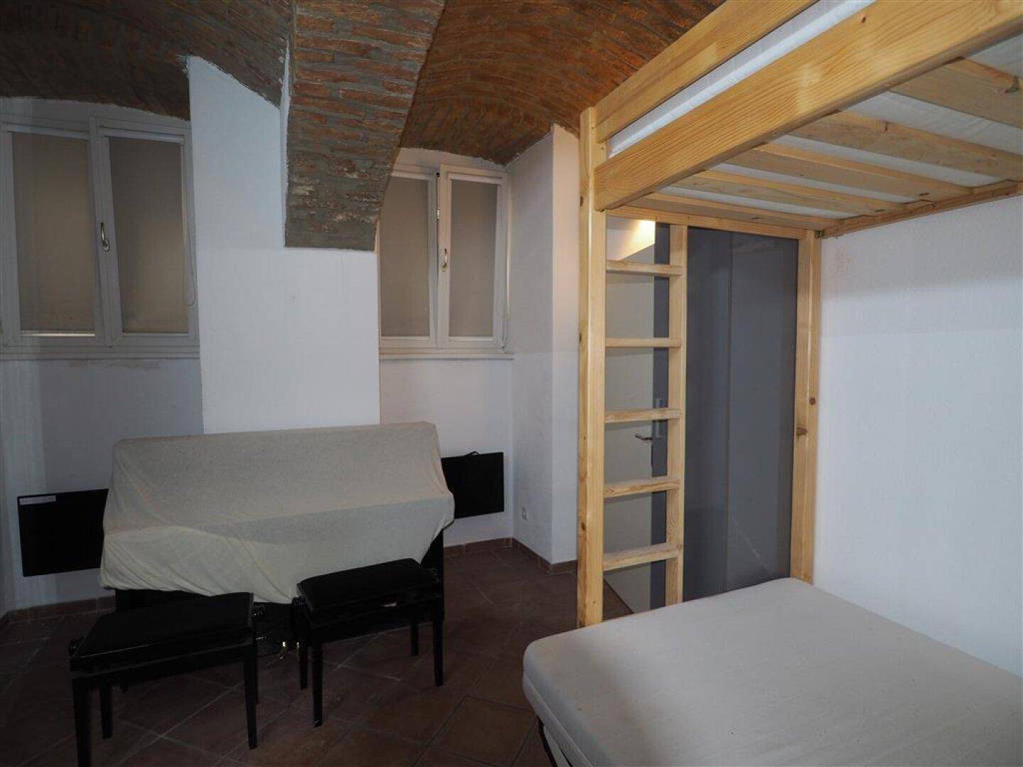 Schlafzimmer mit Etagenbett, Schlafsofa und Terrakottaboden unter einer charakteristischen Gewölbedecke.