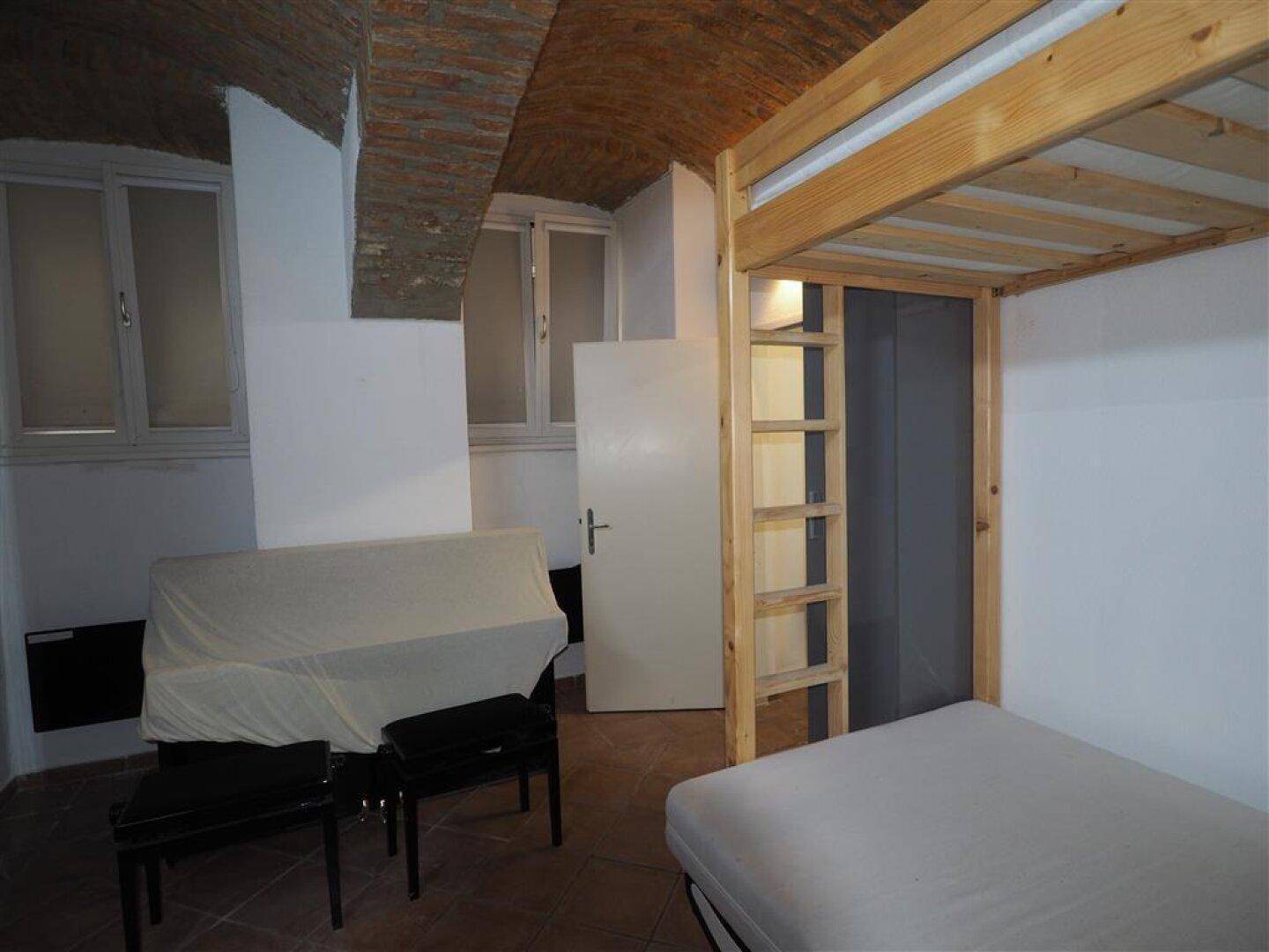 Helles Schlafzimmer mit Etagenbett, Schlafsofa und Fenstern, die natürliches Licht in den Raum lassen.