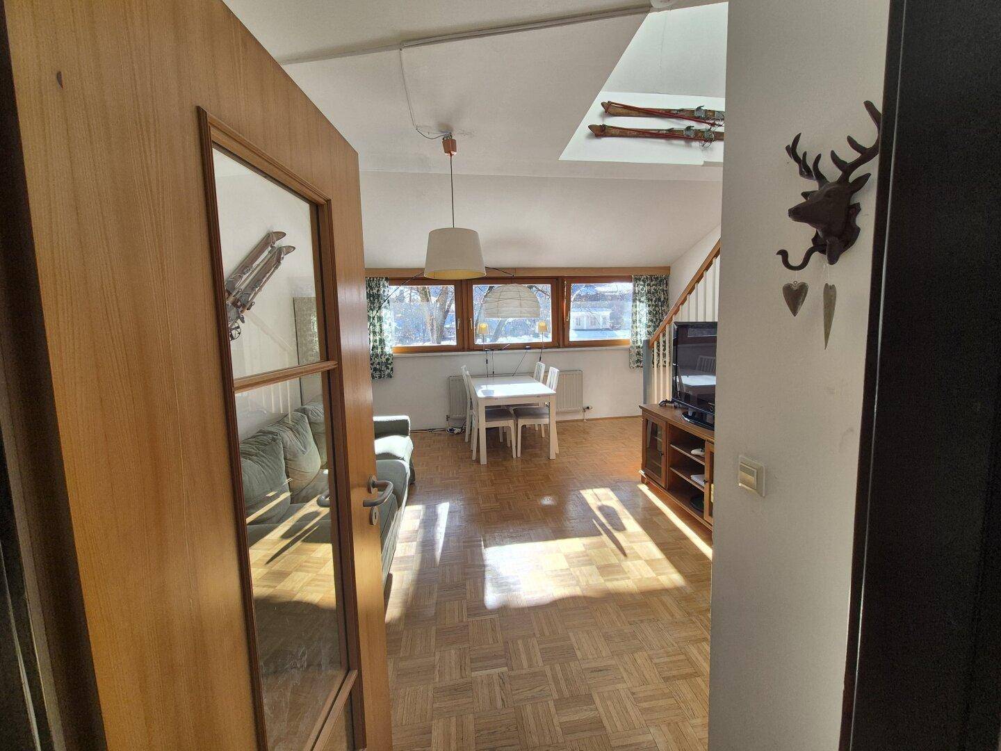 Offener Wohnbereich mit Holzboden, Blick auf die Umgebung und traditioneller Dekoration.