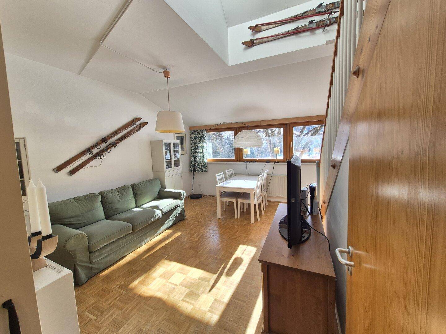 Offener Wohn-Essbereich mit Sofa, Esstisch, Holzboden und traditionellen Akzenten.