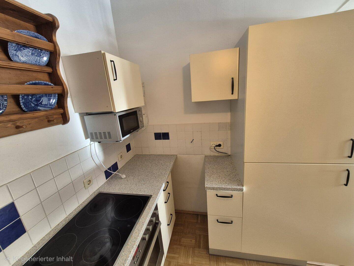 Funktionale Küche mit Mikrowelle, Kochfeld, Backofen und hellen Schränken.