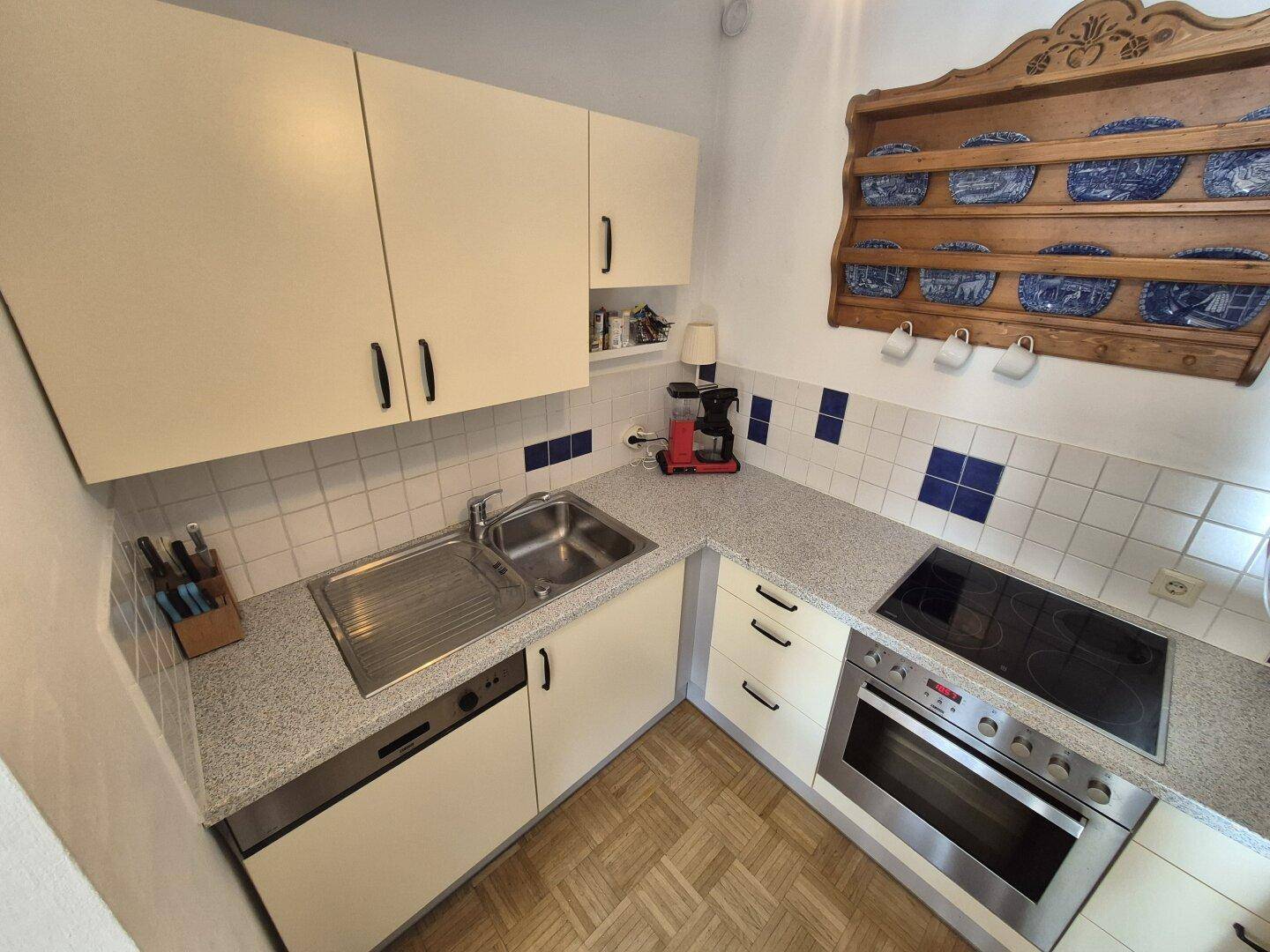 Funktionale Küche mit Spülbecken, Geschirrspüler, Kochfeld und Backofen.