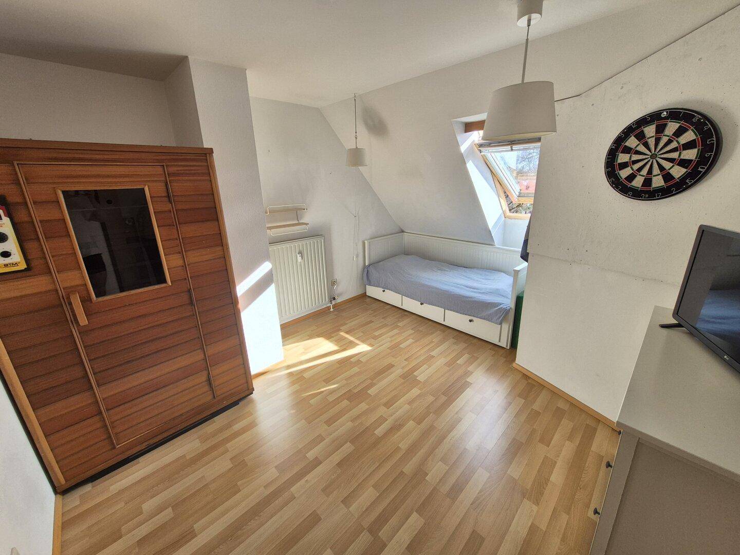 Helles Schlafzimmer mit integrierter Sauna, Einzelbett und Dachfenster.
