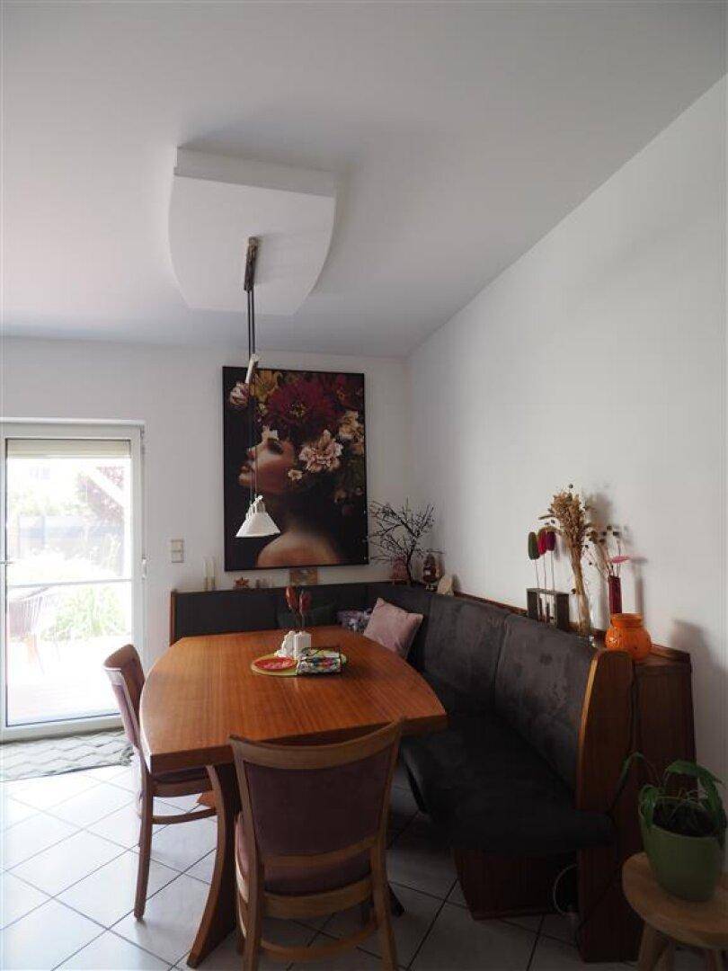 Gemütlicher Essbereich mit Holztisch, Eckbank und Zugang zur Terrasse für Mahlzeiten im Freien.