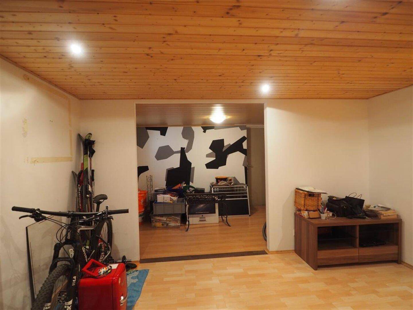 Kellerraum mit Holzdecke, Fahrrädern und Stauraum, ideal als Hobby- oder Abstellraum.