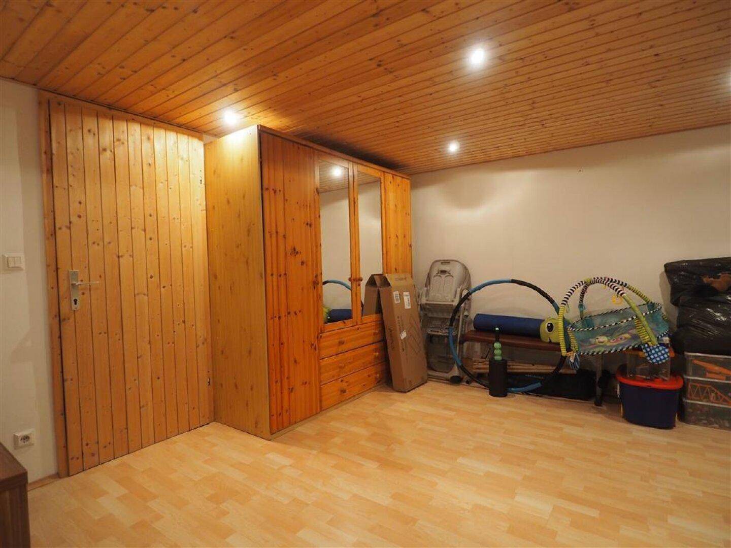 Geräumiger Kellerraum mit Holzschränken und einer Holzpaneeldecke, bietet viel Stauraum.