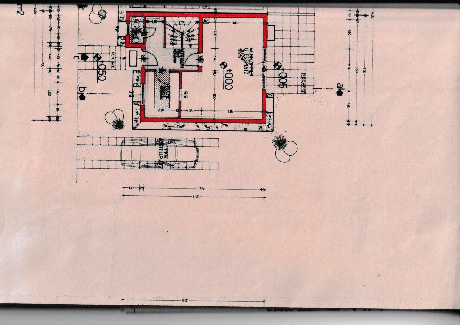 Grundriss des Erdgeschosses mit Wohnbereich, Terrasse und Stellplatz für ein Fahrzeug.