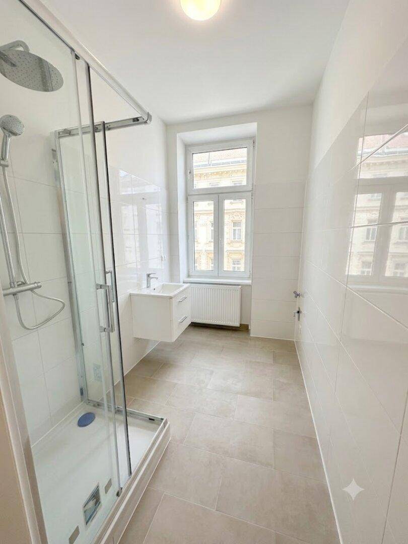 Modernes Badezimmer mit begehbarer Dusche, Einzelwaschbecken und Fenster für Tageslicht.