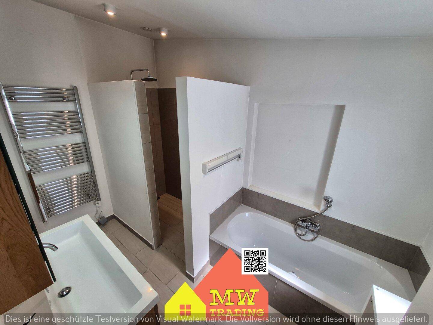 Modernes Badezimmer mit Badewanne, separater Dusche und beheiztem Handtuchhalter.