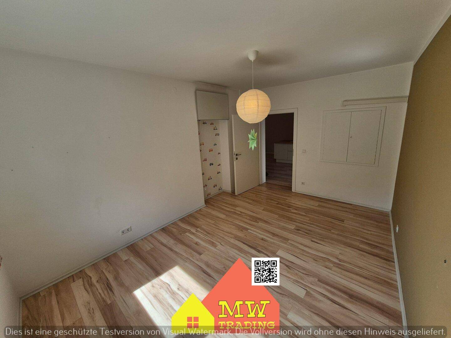 Leeres Zimmer mit Laminatboden und hellem Interieur, bereit zur individuellen Gestaltung.