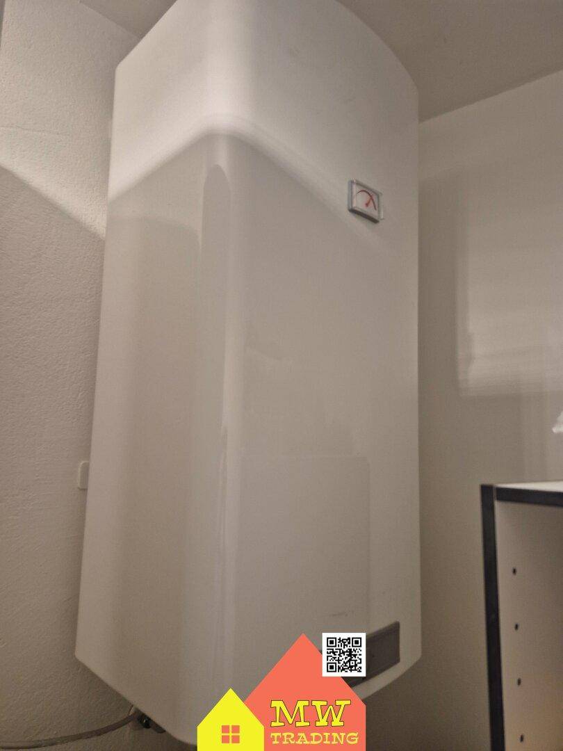 Nahaufnahme eines weißen Warmwasserboilers in einem Hauswirtschaftsraum.