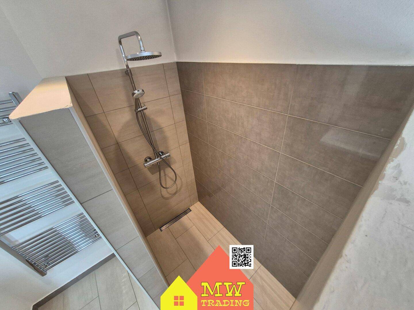 Geräumige, ebenerdige Dusche mit modernen Fliesen und Regenduschkopf.