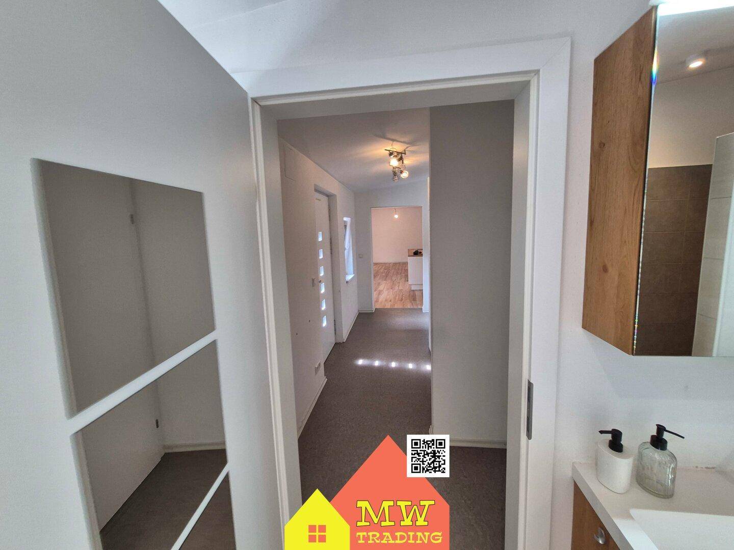 Heller Flur mit Blick auf den Eingangsbereich und angrenzende Zimmer.