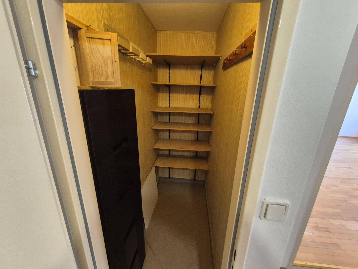 Kleiner Abstellraum mit Regalen und Haken für zusätzlichen Stauraum in der Wohnung.