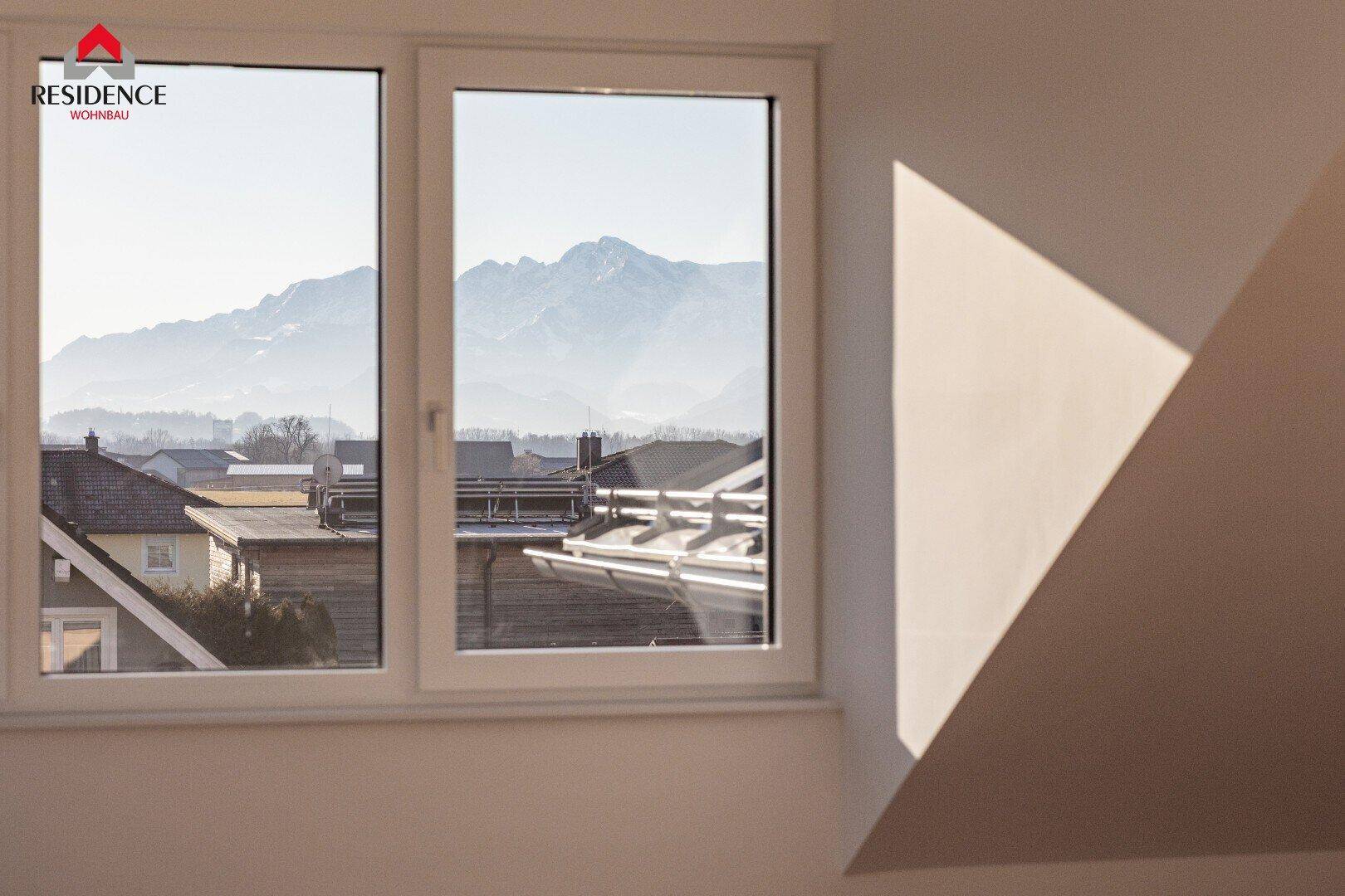Raum mit Bergblick durch ein großes Fenster und viel Tageslicht.