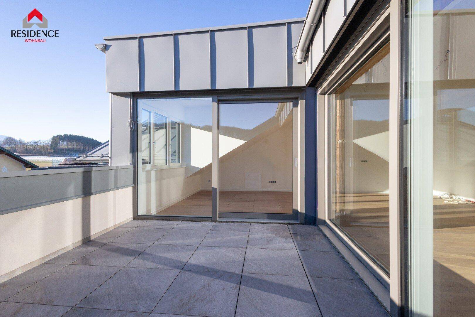Geräumige Dachterrasse mit Fliesenboden und weitem Blick über die Umgebung.