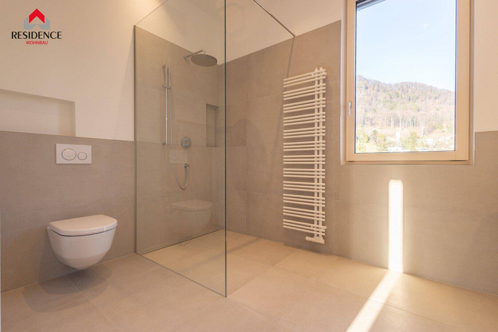 Modernes Badezimmer mit großer begehbarer Dusche, Wand-WC und Fenster mit Bergblick.