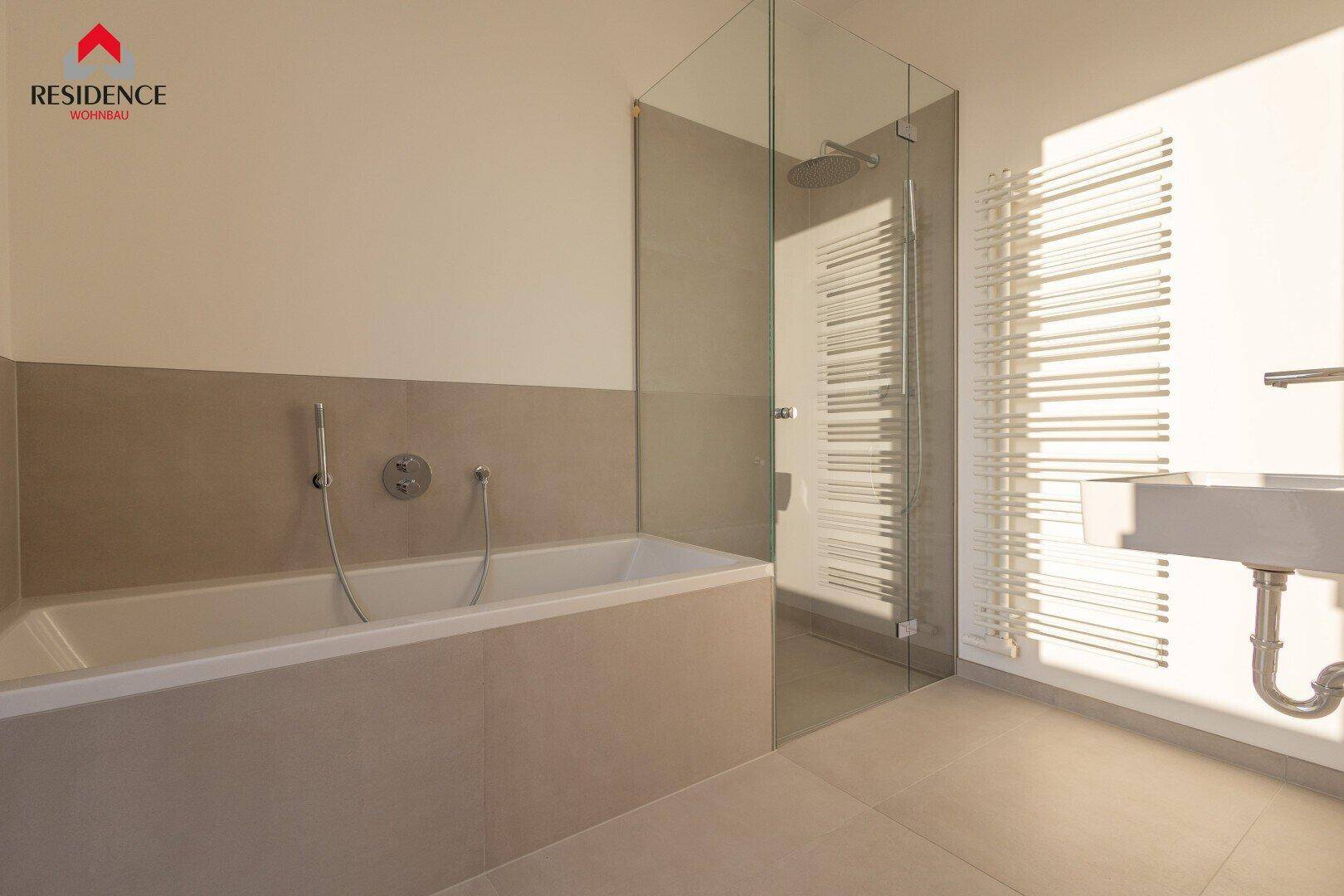 Modernes Badezimmer mit Badewanne, begehbarer Dusche und beheiztem Handtuchhalter.