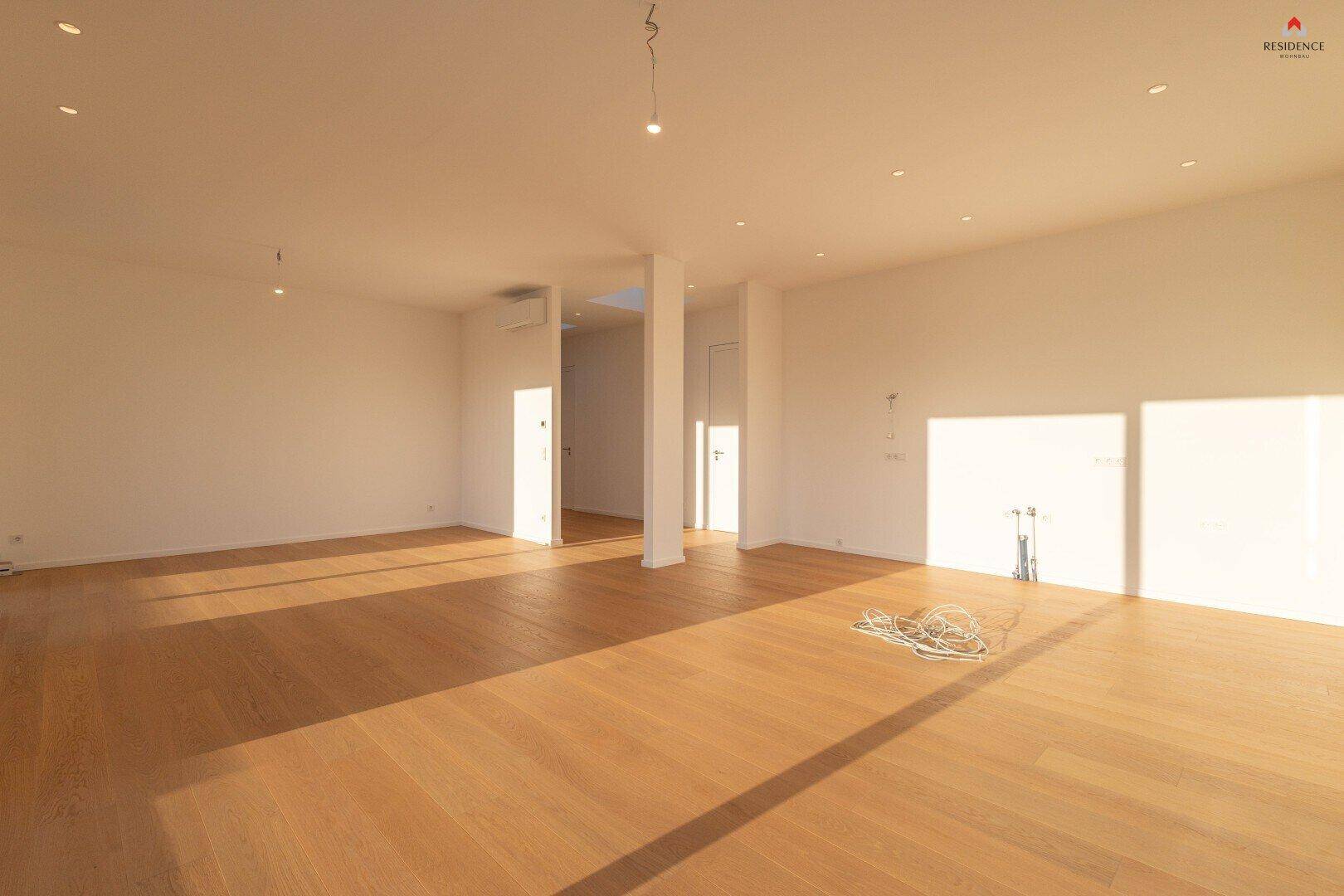 Großer, leerer Raum mit Eichenparkett und viel natürlichem Licht, bereit für die individuelle Gestaltung.