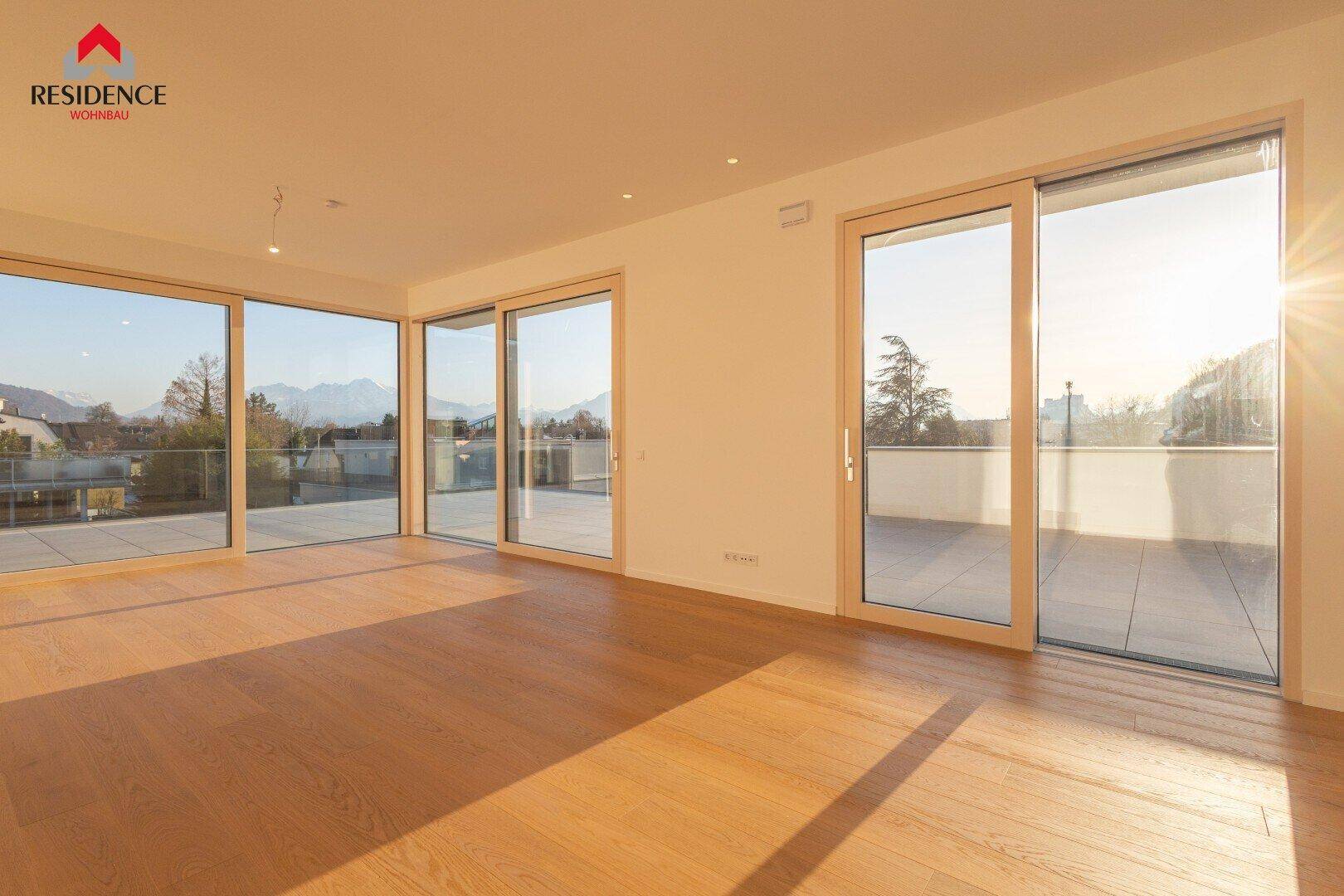 Lichtdurchfluteter Wohnbereich mit Holzboden, großen Fensterfronten und Zugang zur Terrasse.