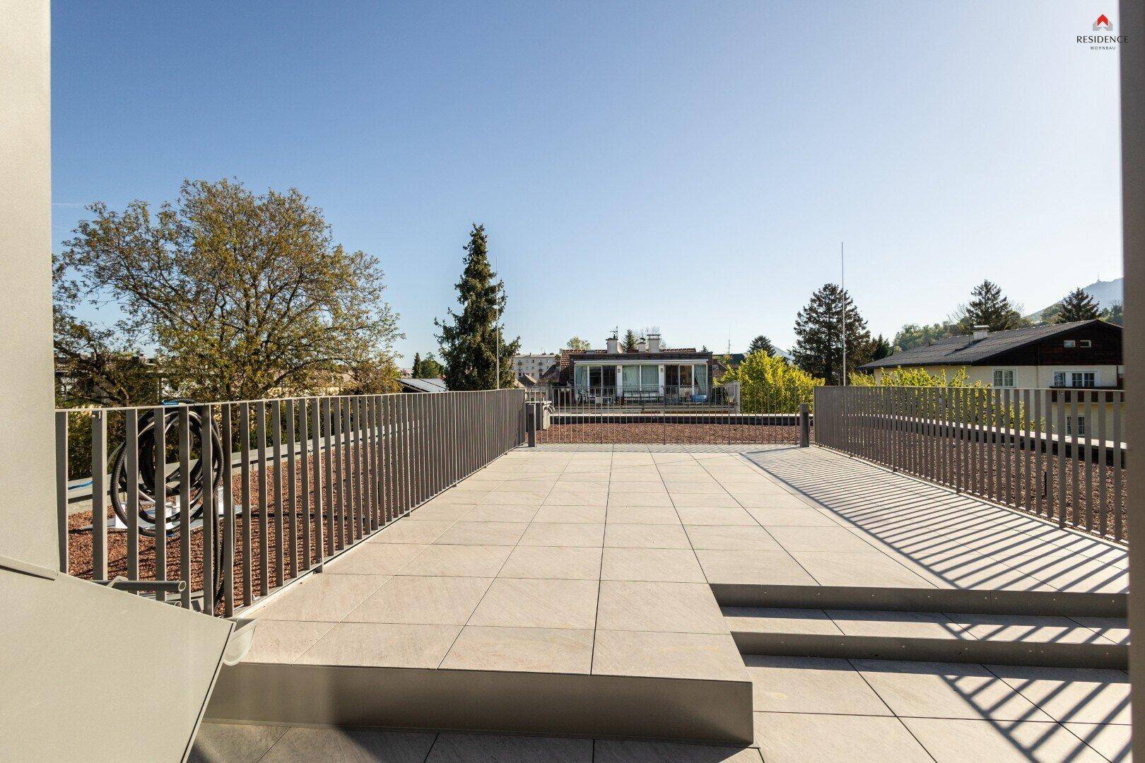 Geräumige, unmöblierte Dachterrasse mit Fliesenboden und weitem Blick über die Umgebung.