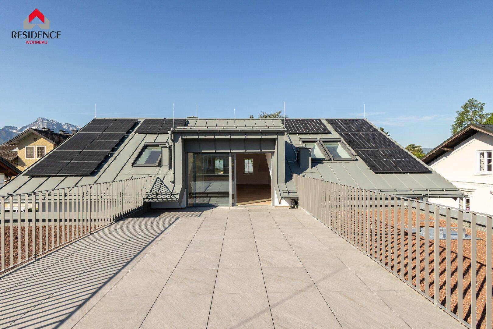 Weitläufige Dachterrasse mit Fliesenboden und Blick auf die umliegende Berglandschaft.