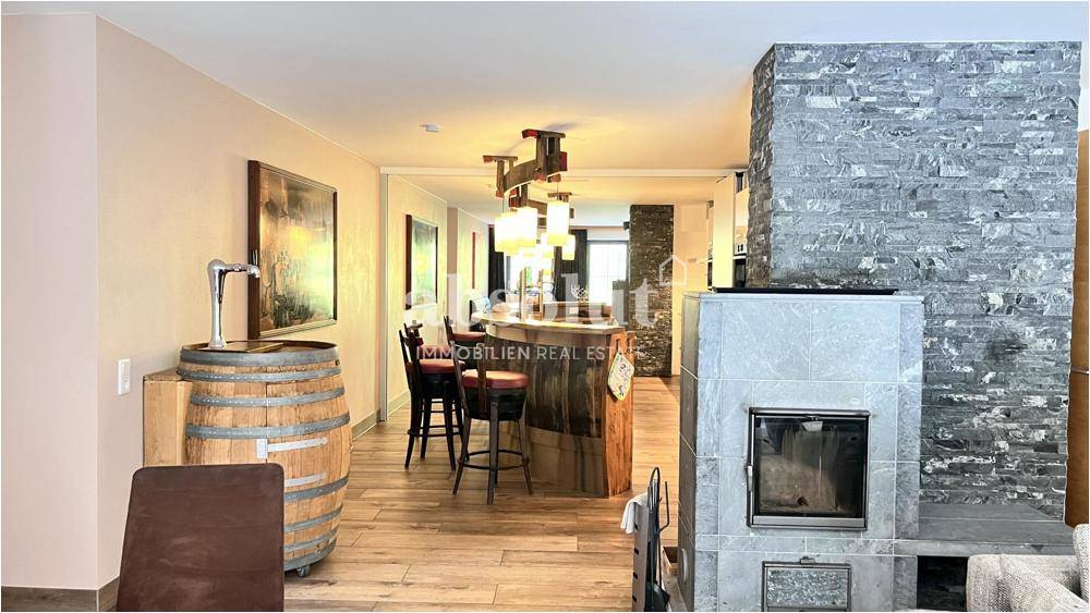Wohnbereich mit Bar, Kamin und Holzboden, ideal für gesellige Abende.