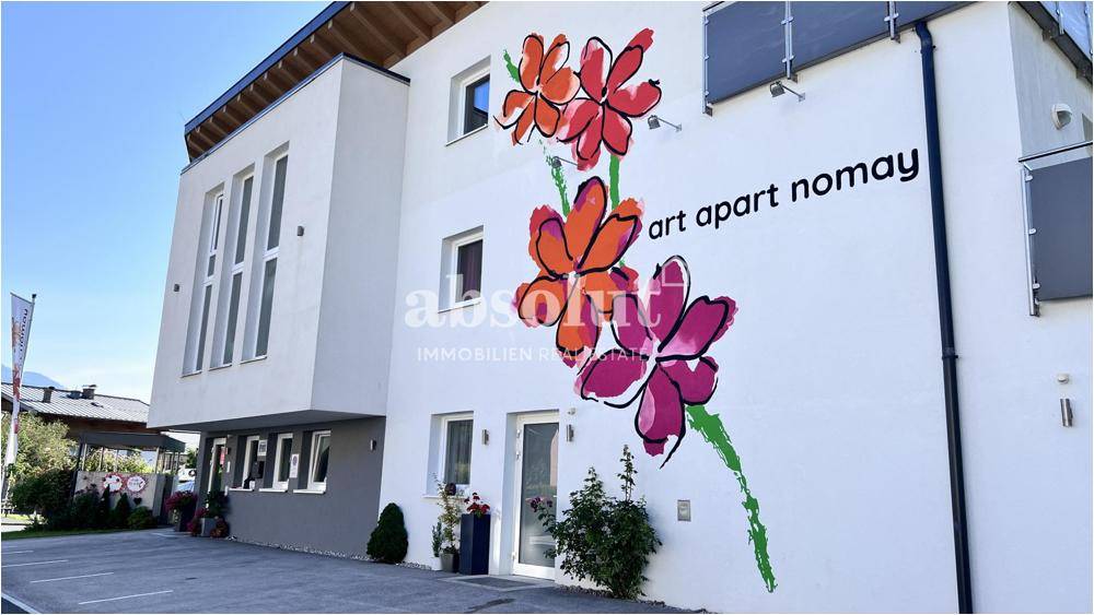 Moderne Gebäudefassade mit auffälligen Blumenmotiven und klaren architektonischen Linien.