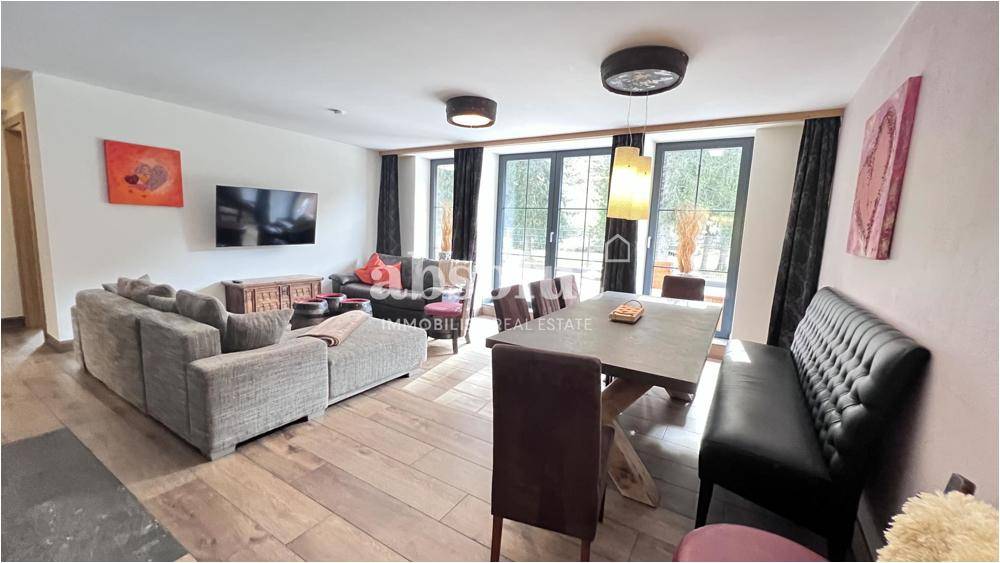 Heller Wohn-Essbereich mit Holzboden, bequemen Sofas und Zugang zur Terrasse.