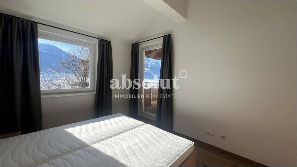 Schlafzimmer mit großen Fenstern, die einen schönen Blick auf die umliegende Bergwelt bieten.