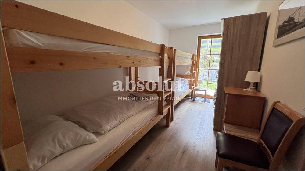 Kinderzimmer mit Etagenbetten aus Holz und Blick ins Grüne, ideal für Familien.
