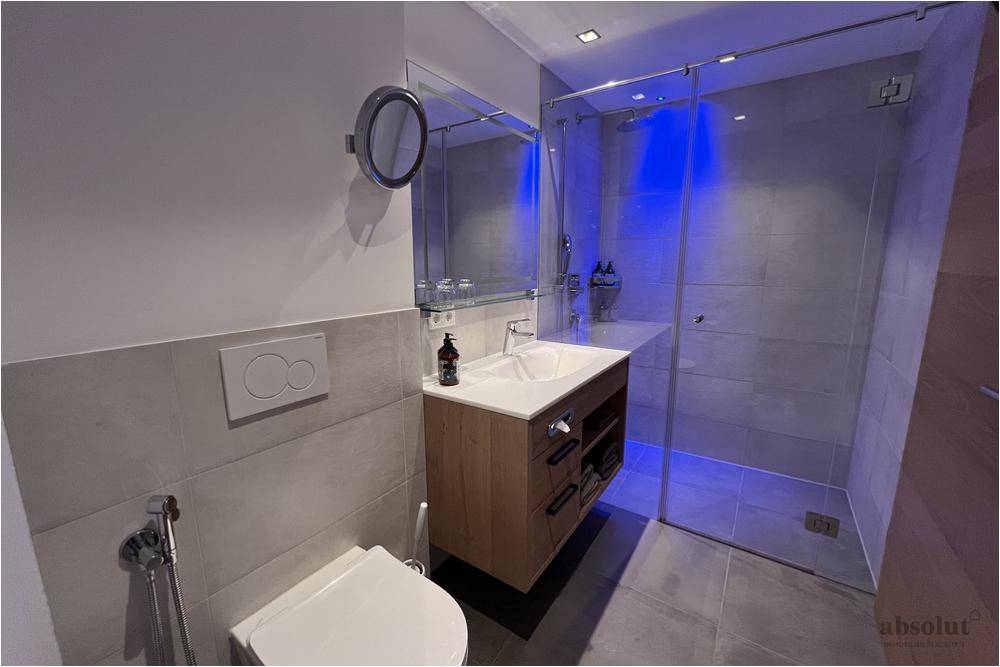 Modernes Badezimmer mit begehbarer Dusche, Wand-WC und stilvollen Fliesen.