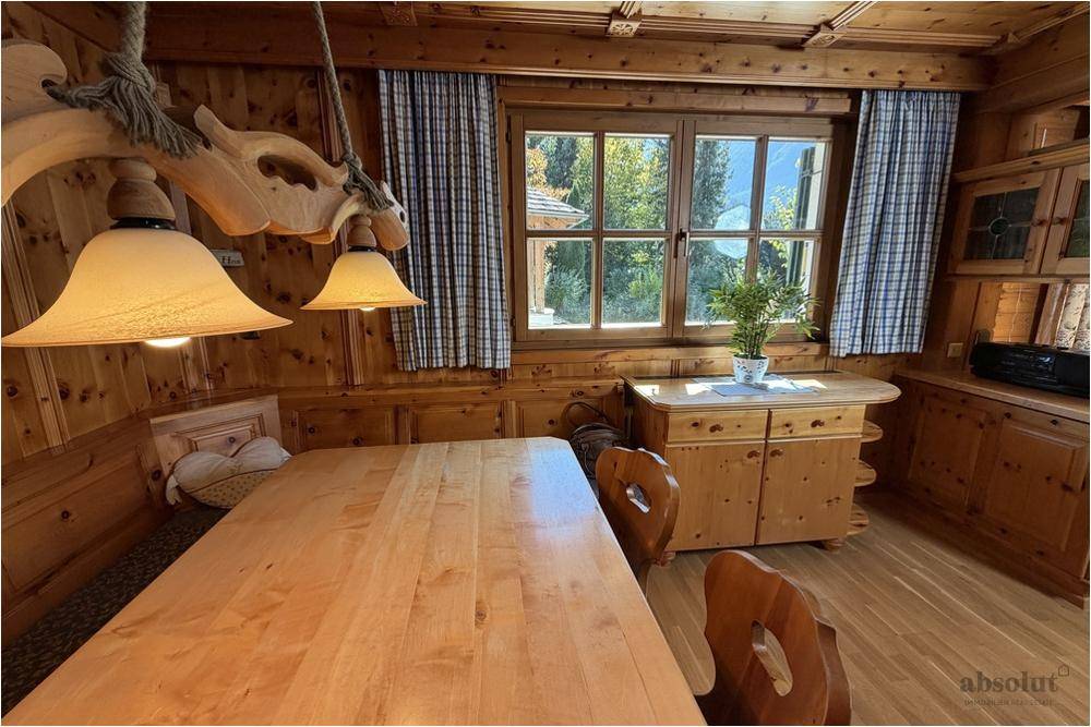 Heller Essbereich mit Holztisch, traditioneller Beleuchtung und Blick ins Grüne.