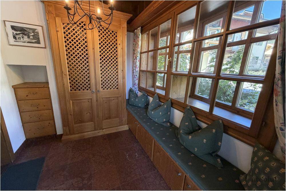 Heller Eingangsbereich mit Holzmöbeln, Fensterbank und traditionellem Charme.