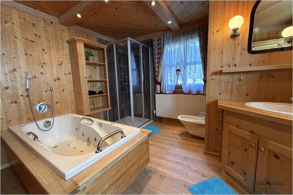 Rustikales Badezimmer mit Holzverkleidung, Whirlpool-Badewanne und separater Dusche.