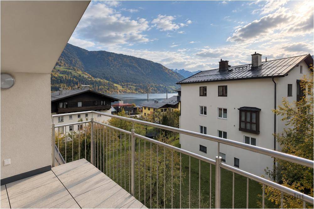 Geräumiger Balkon mit Fliesenboden und weitem Blick auf den See und die Berge.