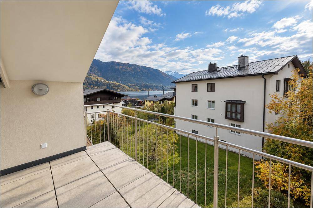 Balkon mit Blick auf den See, die Berge und die umliegende Wohnbebauung.