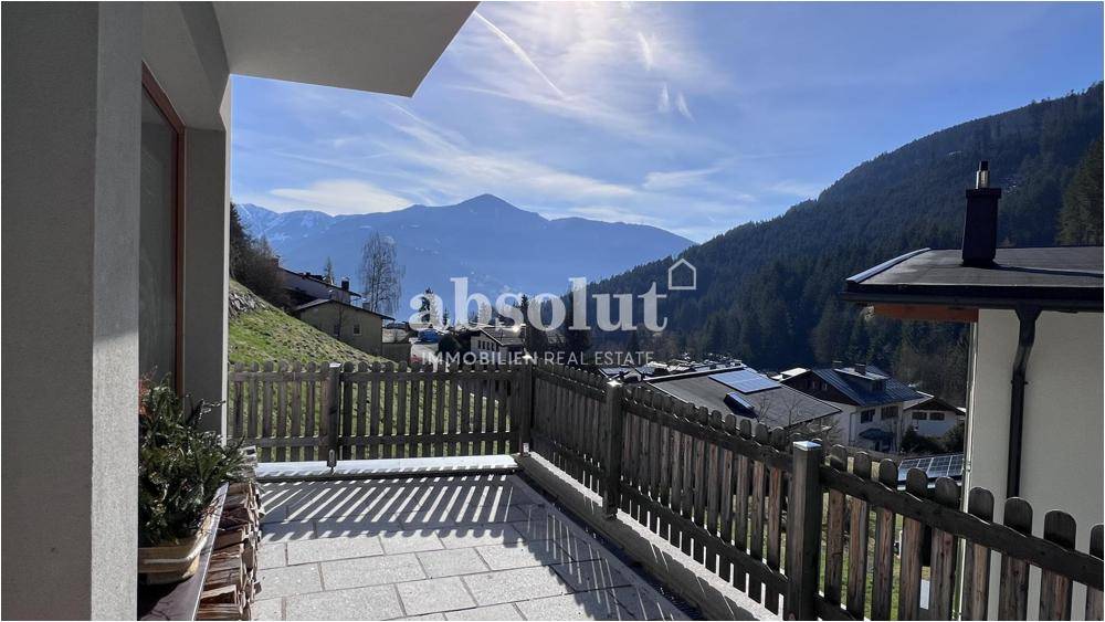 Sonniger Außenbereich mit gepflastertem Boden und weitem Blick auf die umliegende Berglandschaft.