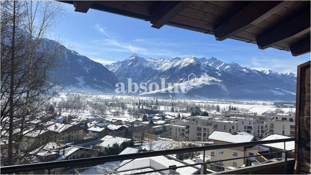 Panoramablick vom Balkon auf die verschneite Berglandschaft und das darunterliegende Tal.